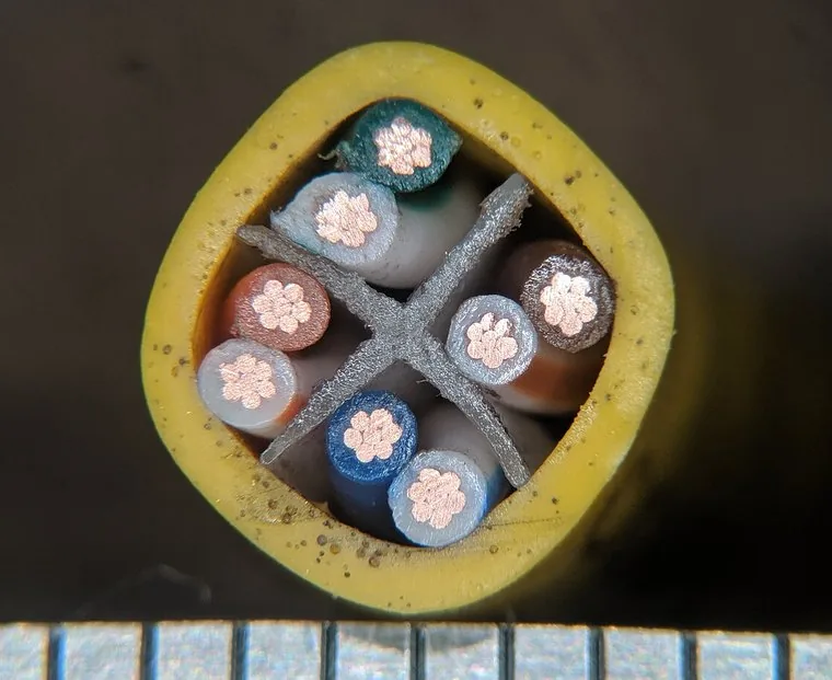 Cut end of a Cat6 cable: a grey cross-shaped spline holds the four pairs apart